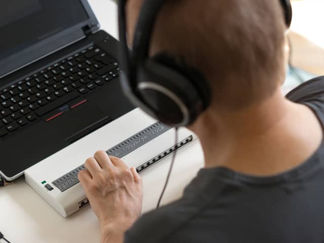 Global Accessibility Awareness Day focuses on digital access and inclusion for people with disabilities or impairments. (Image shows visually impaired person working on computer with assistive technology) 