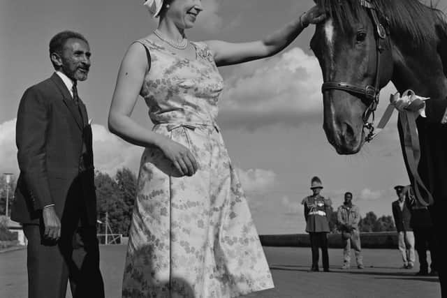 Queen Elizabeth II patting on the forehead of a horse while Ethiopian emperor Haile Selassie (1892 - 1975) is standing next to her during her visit to Ethiopia, 5th February 1965. (Photo by Terry Fincher/Daily Express/Hulton Archive/Getty Images)