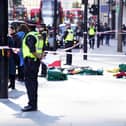 Police officers at the scene after three people have been taken to hospital following reports of stabbings at Bishopsgate in London. Picture date: Thursday October 6, 2022.