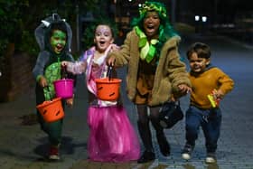 Children pose for a picture as they go trick-or-treating for Halloween in east London. 