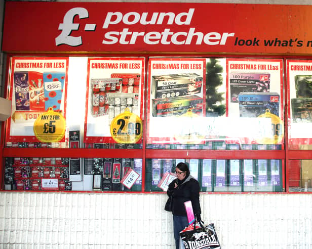 A woman waits outside a branch of Poundstretcher near Lewisham high street.