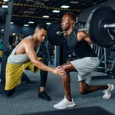 Man with his trainer in gym (Adobe)