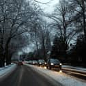 Cars drive on snowy roads in Liverpool.