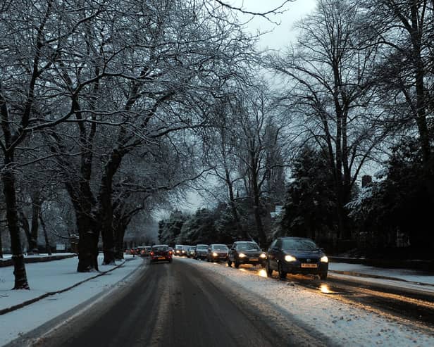 Cars drive on snowy roads.