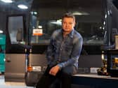 Jeremy Renner on set of Rennervations, a bus behind him and some power tools to one side (Credit: Disney+)