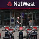 Pedestrians walk past a branch of a NatWest bank in London.