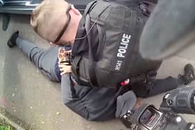 Deraj Meade being arrested by armed police.  