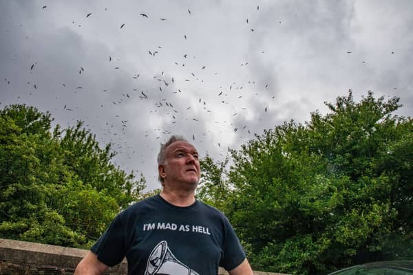 Gary Hough, 62, looks up to the skies outside his home surrounded in seagull