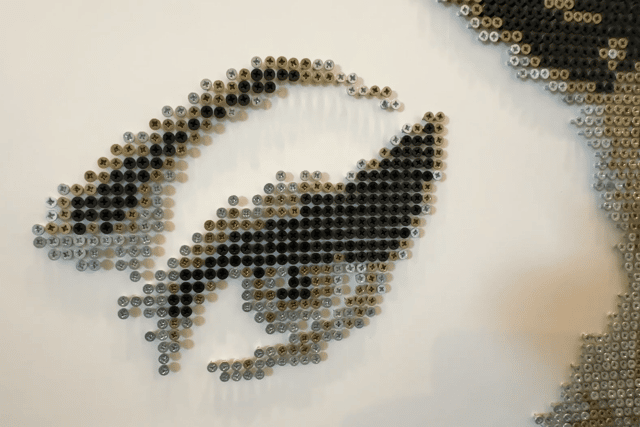 A photo of an art piece resembling Amy Winehouse made with screws by Darren.