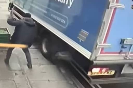 This pedestrian comes within feet of being hit by a lorry mounting a pavement