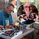 Mark Taylor, a retired art teacher, paints music-themed portraits and album sleeves onto old tin lids and leaves them for gig-goers to take at Waterloo Music Bar.