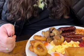 Kalani Smith reviewing a full English breakfast. British cafe goes viral after US TikToker gives glowing reviews of a full English breakfast.