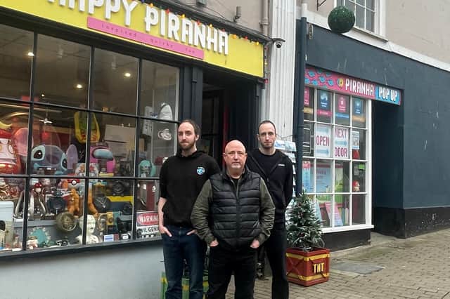 Happy Piranha store owner Martin Gaunt (centre) outside his store with sons Sam and Josh.