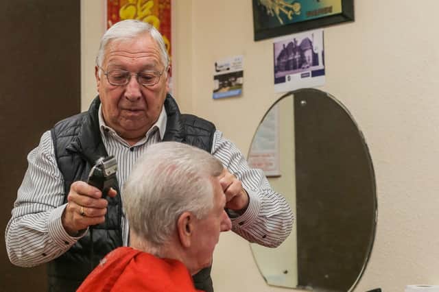 Melvin Eley cutting hair at his barbershop in Stechford, Birmingham.