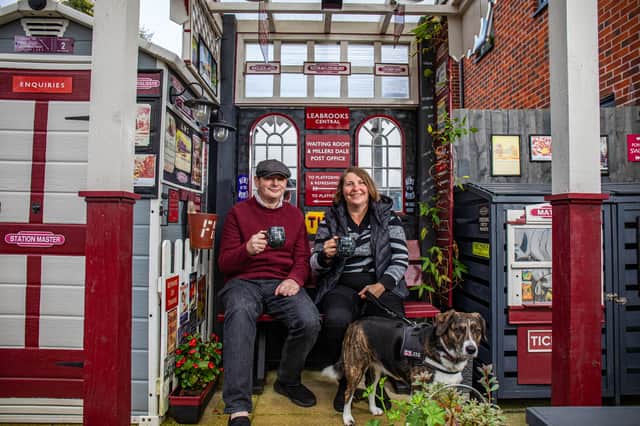 Train mad couple Richard Cantrell and Katherine Siggins with dog Jess in the back garden at their home-made 'station'.