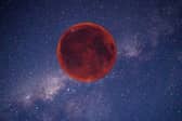 Digitally created image of a red Moon in the night sky.