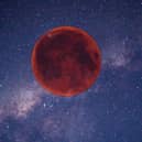 Digitally created image of a red Moon in the night sky.