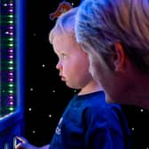 Young boy and grandparent enjoy Autism Plus Nook Stop Sensory Pod.