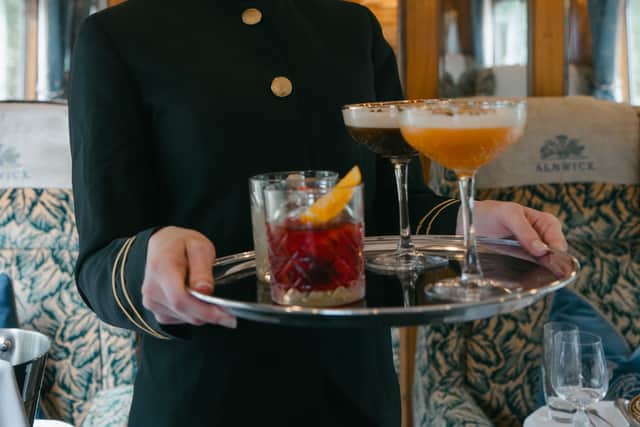 Cocktail time ... a liveried steward serves drinks aboard the train
