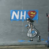 A woman looks at a mural of an NHS worker outside a pub in Pontefract, West Yorkshire. Pic: Jonathan Gawthorpe