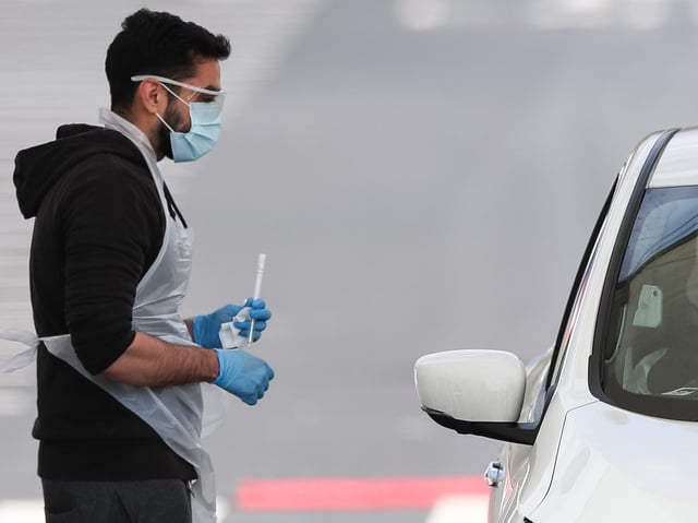 A tester administers a coronavirus test at a testing site near Manchester Airport, as the UK continues in lockdown to help curb the spread of the coronavirus. Photo: PA