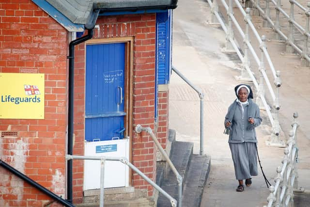 A woman walks along the sea front in Whitby, Yorkshire , after the introduction of measures to bring the country out of lockdown. Photo: PA