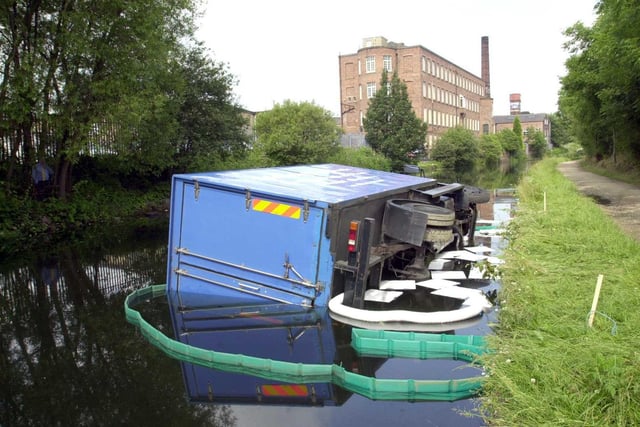 A Macduff meat lorry lays on its side in the Leeds Liverpool Canal.