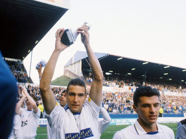 Vinnie Jones holds the championship trophy aloft.