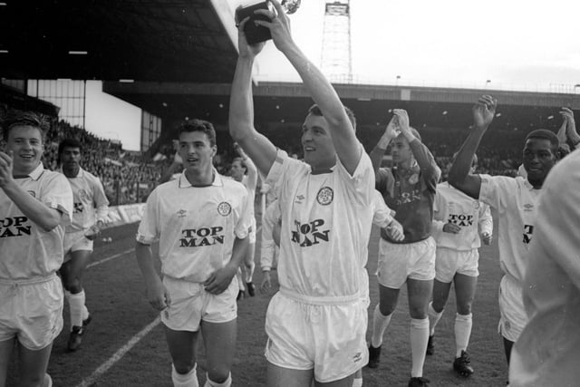 Mike Whitlow holds aloft the trophy as the players enjoy a lap of honour.