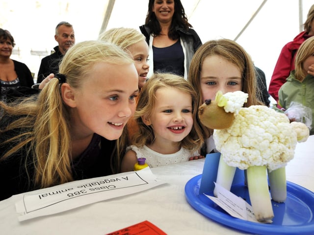Children viewing a sheep made of vegetables.