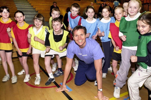 Friday 16th January 2004 - Olympic silver medalist and 400m champion, Roger Black, ready for the start of the Primary School Indoor Athletics competition at Robin Park, pictured with pupils from St. Aidans, St. Judes, Beech Hill and Pemberton Primary Schools.  He was visiting Wigan to promote an exercise programme for over 50's and to present awards for Wigan Council - on the same day that London unveiled plans for its bid for the 2012 Olympic games.