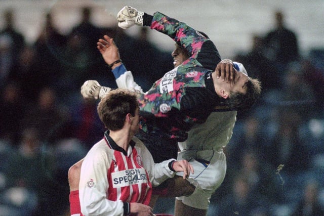 Walsall goalkeeper Trevor Watson is left unsighted by this challenge from Brian Deane.