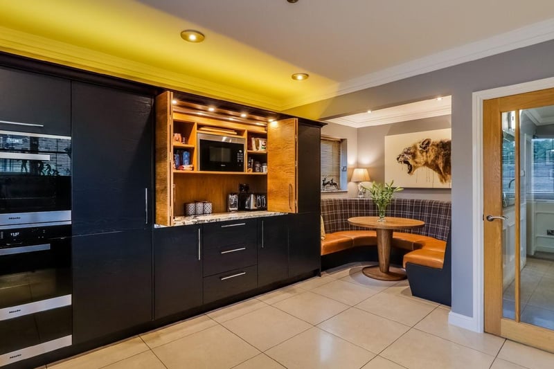 Stylish and contemporary fitted kitchen with a host of appliances and adjoining breakfast area.