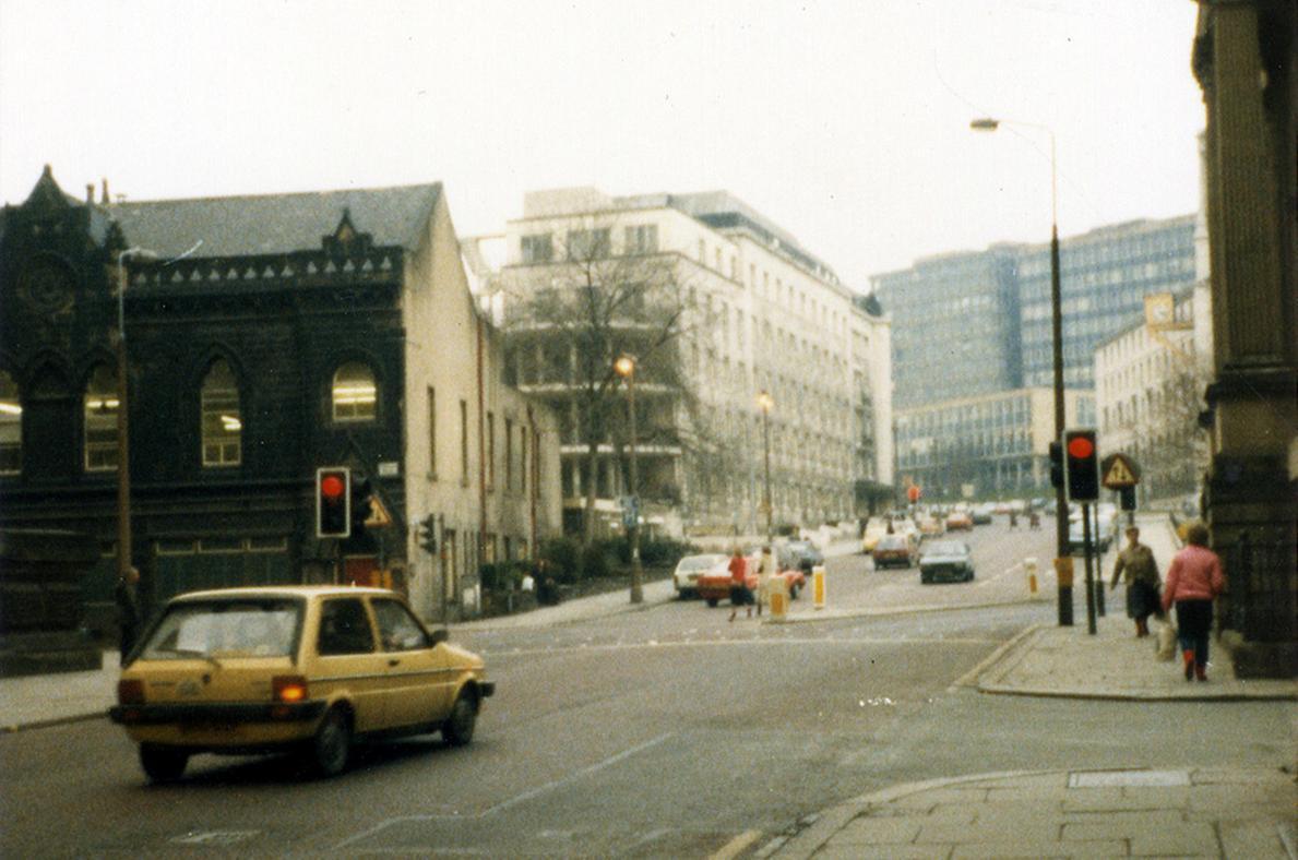 Calverley Street showing the junction with Alexander Street on the right. Just beyond this, the edge of the Education Offices can be seen. In the background are the Brotherton Wing of Leeds General Infirmary and buildings of Leeds Polytechnic.