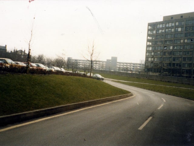 A view across the Inner Ring Road to the buildings of Leeds Polytechnic (now Leeds Metropolitan University) on the right, taken from Vernon Road. A multi-storey car park on New Woodhouse Lane is seen in the centre background, while an outdoor car park is on the left.
