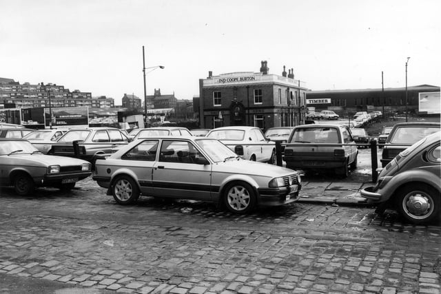 Woolman Street across a busy car park towards Marsh Lane in January 1985. The Smith's Arms public house is seen in the centre background. Rising up on the far left are the flats of Saxton Gardens.