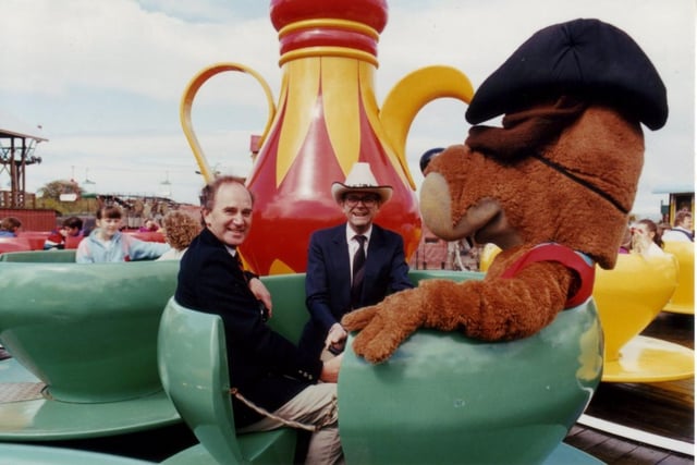 The Frontierland mascot, Frontier Fred, takes a spin on the teacup ride, but does anyone recognise the two men in the picture with him?