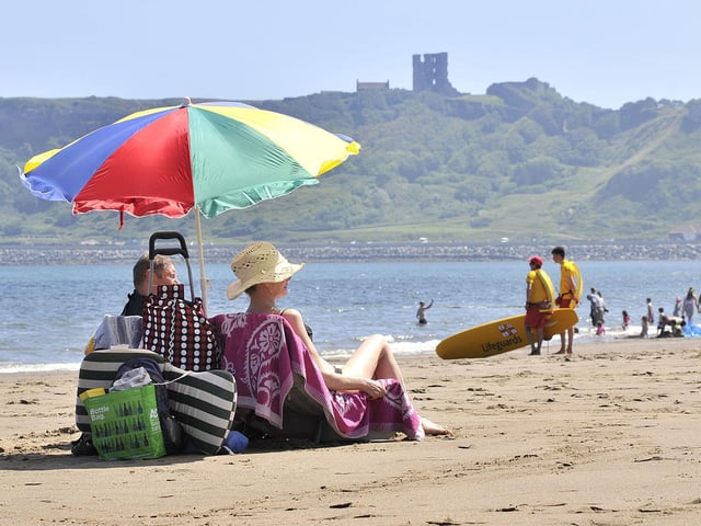 Taking colourful cover from the hot sun in Scarborough's North Bay. 
The Met Office is warning people vulnerable to extreme heat that they are likely to experience 'adverse health effects' while 'some changes in working practices and daily routines' are likely to be required, according to the forecaster