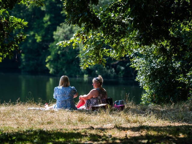 Helen Lord, of Wakefield, with friend Suzanne Newlove, of Leeds, sitting under the trees during the midday sun whilst in Roundhay Park, Leeds