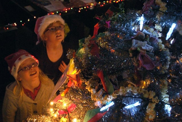 Morecambe Parish Church was magically transformed for the annual Christmas Tree Festival . Georgina and Emily Peck admire one of the displays. This was taken in 2009.
