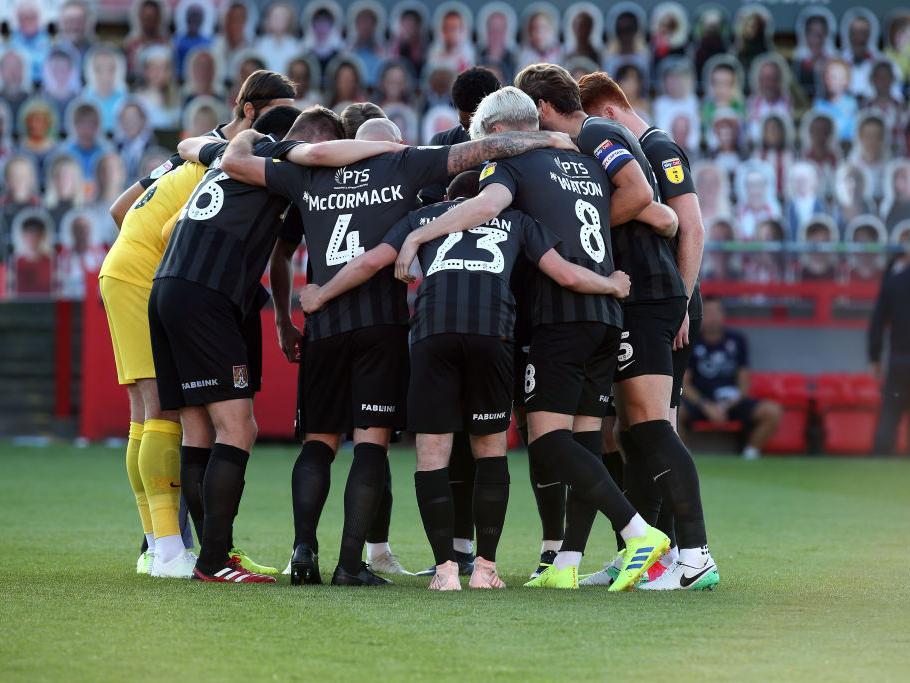 Cobblers players in a huddle before their win at Cheltenham in the play-off semi-final.
