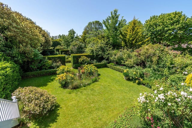 The garden includes a central box parterre, ornamental pond and large kitchen garden with a greenhouse to one side.