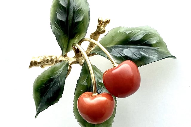 A lapidary 1950s brooch, with coral cherries and nephrite jade leaves on a 14ct gold branch. Hallmarked Irmgard Bures, Vienna, Austria. It will be offered at €1,450 by Precious Flora.