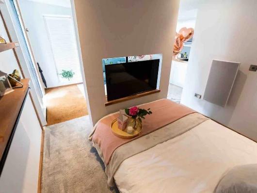 The TV pivots in the wall so you can watch it from the living room area and the bed!