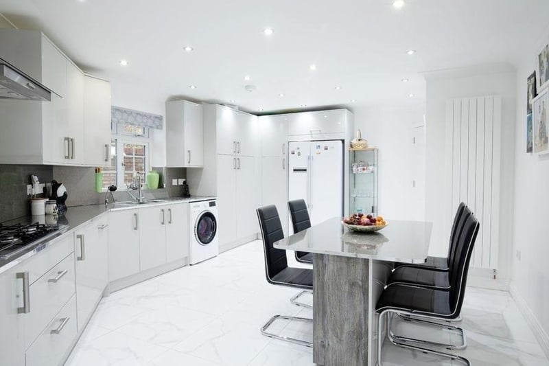 The kitchen is fitted with a range of wall and base units, built-in oven and hob with overhead extractor fan