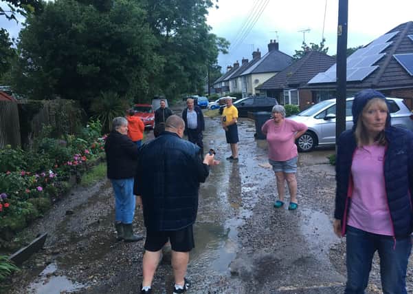 Freeks Lane residents look at the aftermath of the flood.