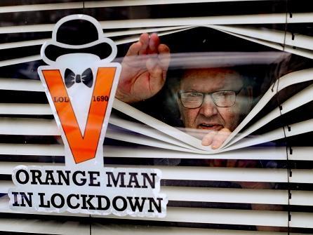 Orange Man, Randy Davidson, who is isolating at home, poses with a sticker in his window to celebrate the Twelfth as traditional large-scale parades were cancelled this year due to the pandemic.