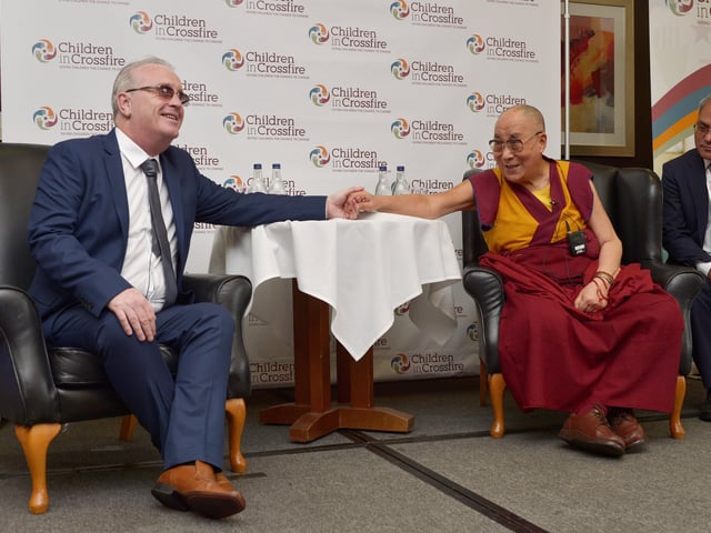 Richard Moore and the Tibetan spiritual leader the Dalai Lama hold hands at the City Hotel press conference in 2017. The Dalai Lama is the patron of the Children in Crossfire charity, founded by Richard Moore. The visit to the city marked the organisation’s 20th anniversary. DER3717GS009