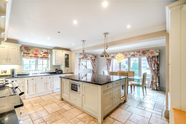 The open plan kitchen and breakfast room has an AGA range, bespoke cabinetry with granite worktops, a central island and integrated appliances.