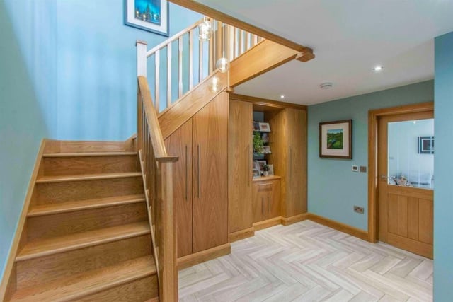 A solid oak staircase with fitted storage beneath is a feature of the entrance hallway.